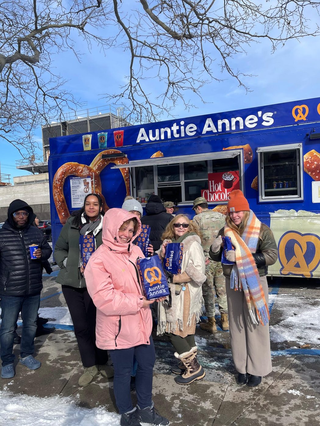 Families holding pretzel bags at a winter community event in NYC