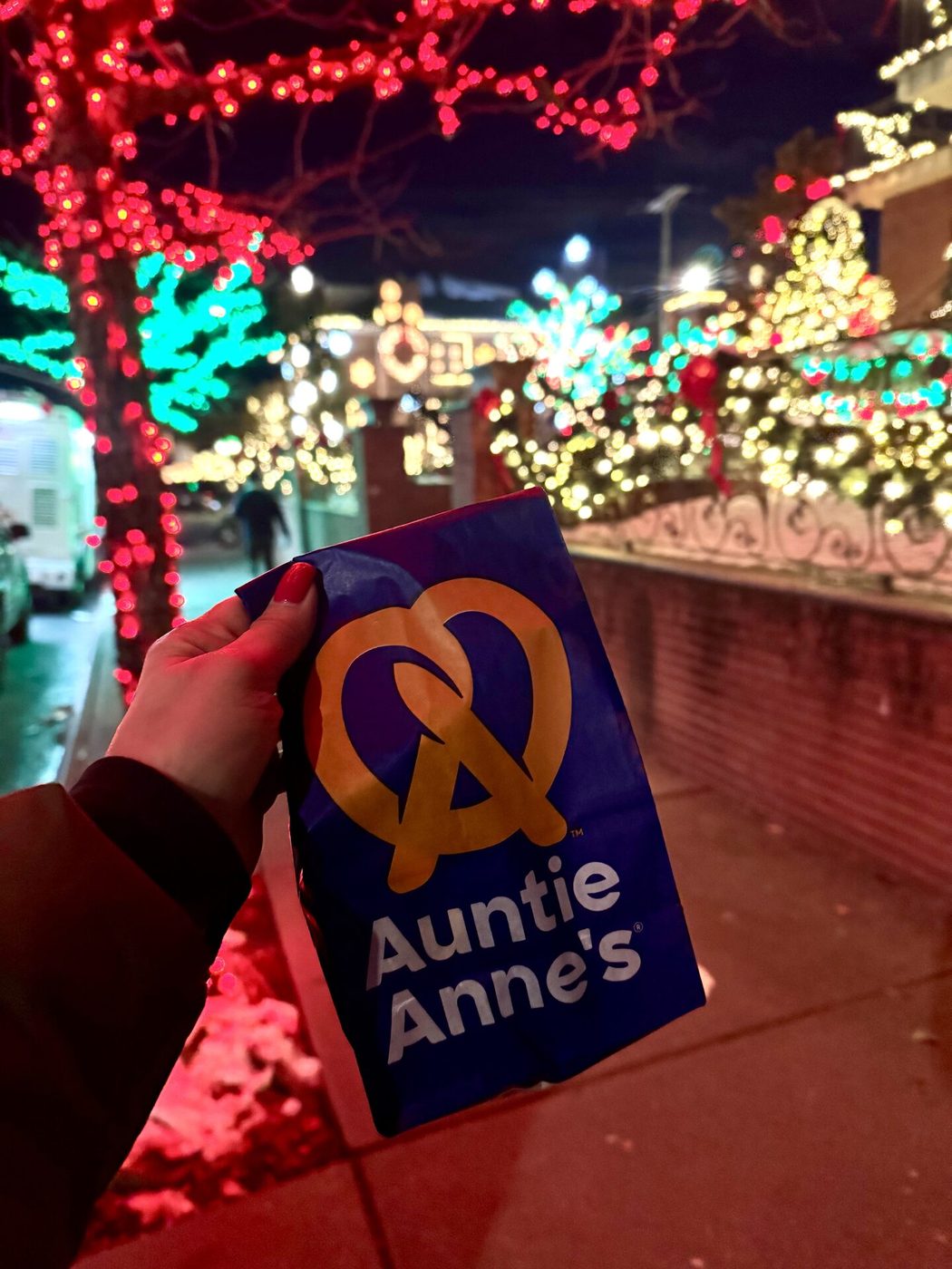 Auntie Anne's pretzel bag against holiday lights at an NYC event